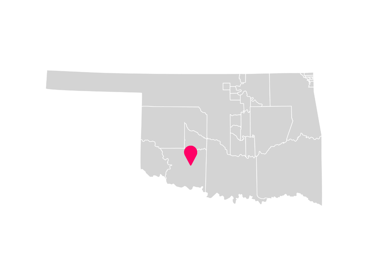 A gray map showing the tribal jurisdiction areas of Oklahoma with a pink pin marking Lawton, Oklahoma, where the Comanche Nation is headquartered.
