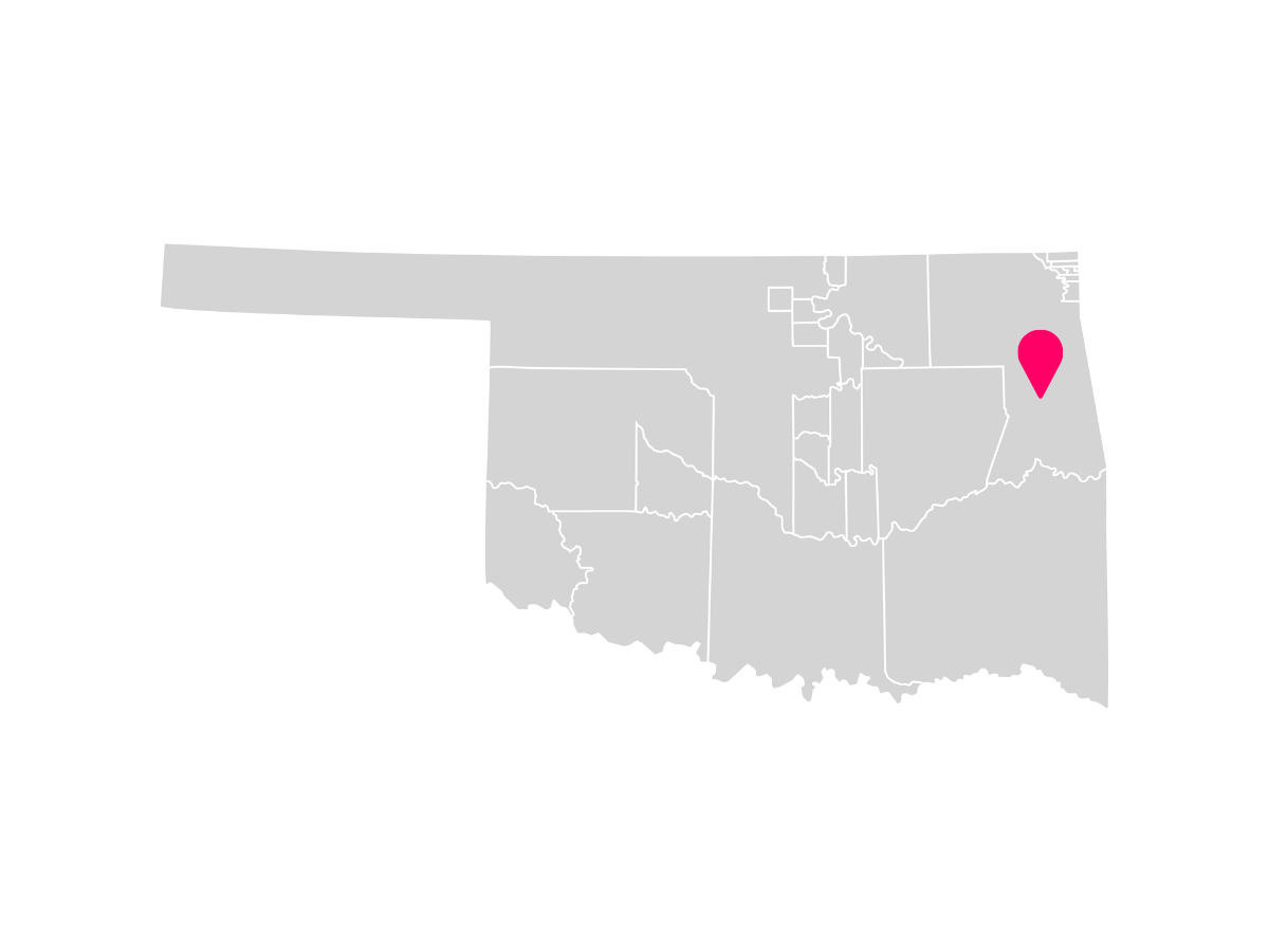 A gray map showing the tribal jurisdiction areas of Oklahoma with a pink pin marking Tahlequah, Oklahoma, where the Cherokee Nation is headquartered.
