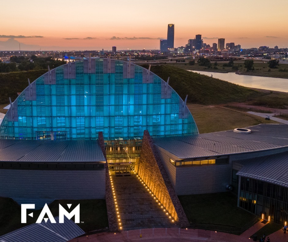 A photograph of the First Americans Museum building from a drone at sunset highlighting the front entrance to the Hall of the People.