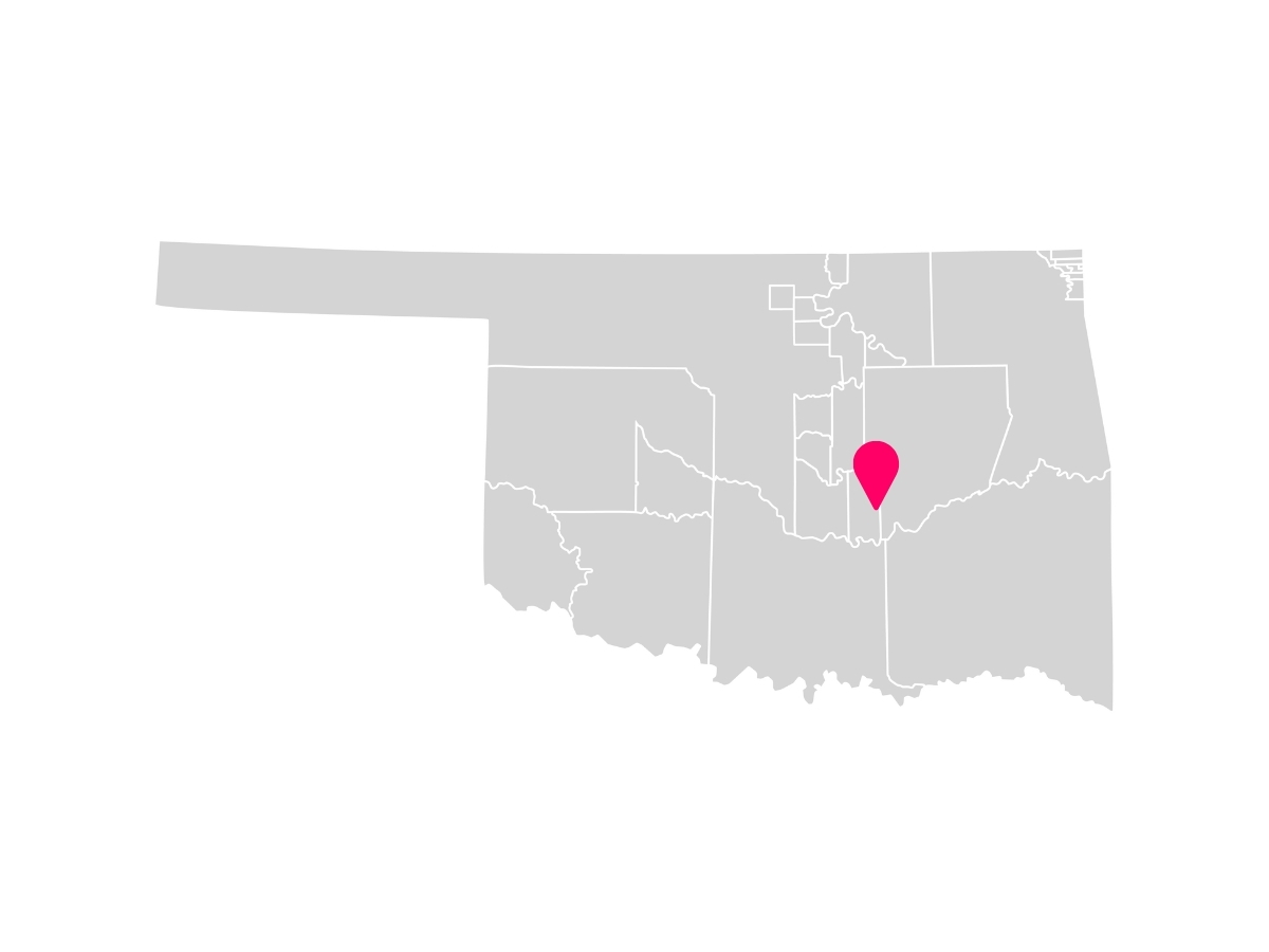 A gray map showing the tribal jurisdiction areas of Oklahoma with a pink pin marking Wewoka, Oklahoma, where the Seminole Nation is headquartered.
