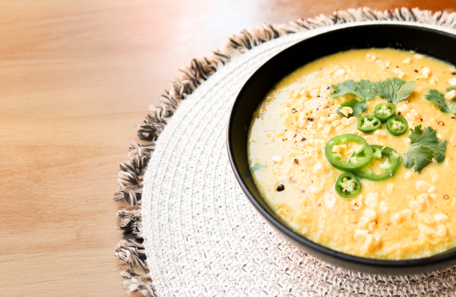 Corn soup in a bowl on a wooden table.