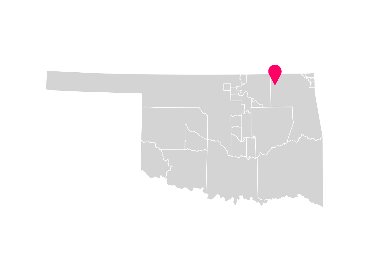 A gray map showing the tribal jurisdiction areas of Oklahoma with a pink pin marking Bartlesville, Oklahoma, where the Delaware Tribe of Indians is headquartered.