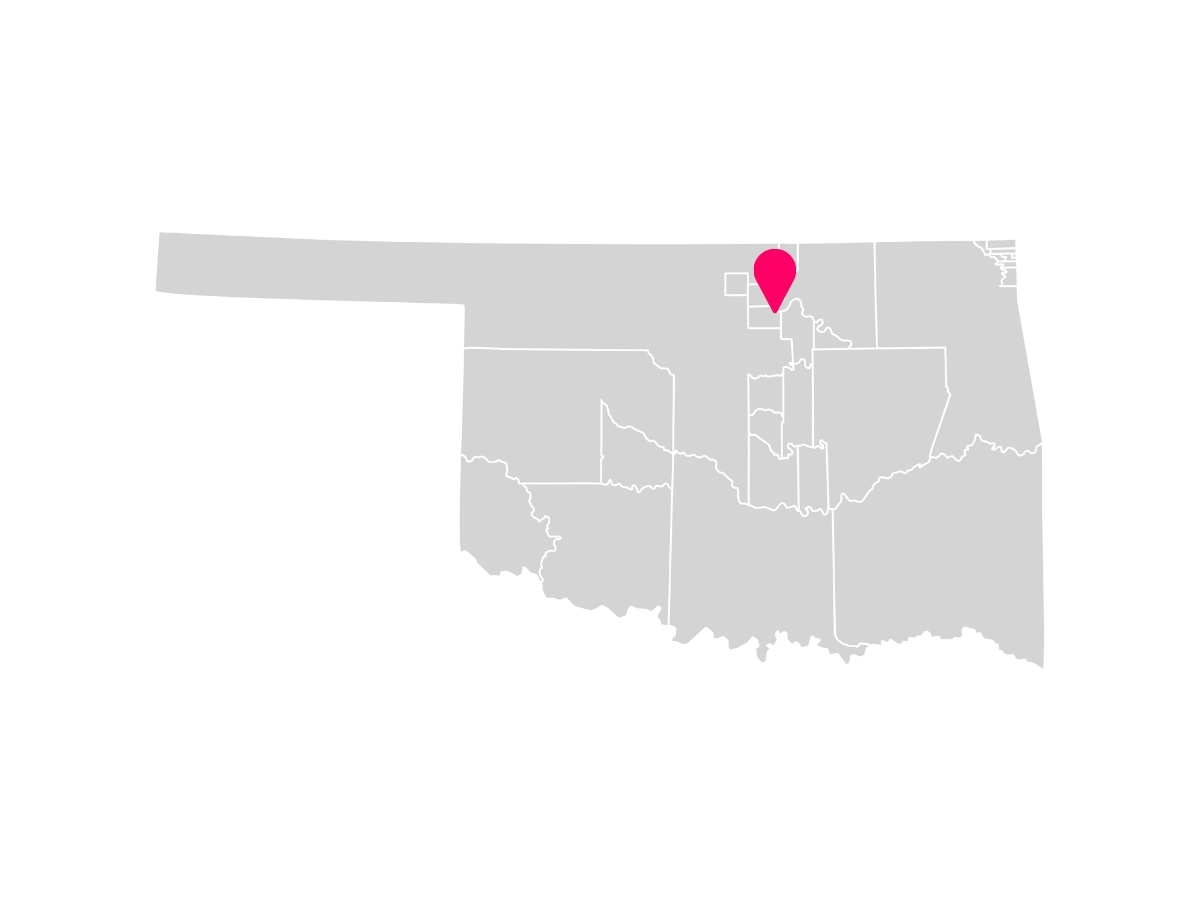 A gray map showing the tribal jurisdiction areas of Oklahoma with a pink pin marking Red Rock, Oklahoma, where the Otoe-Missouria Tribe is headquartered.