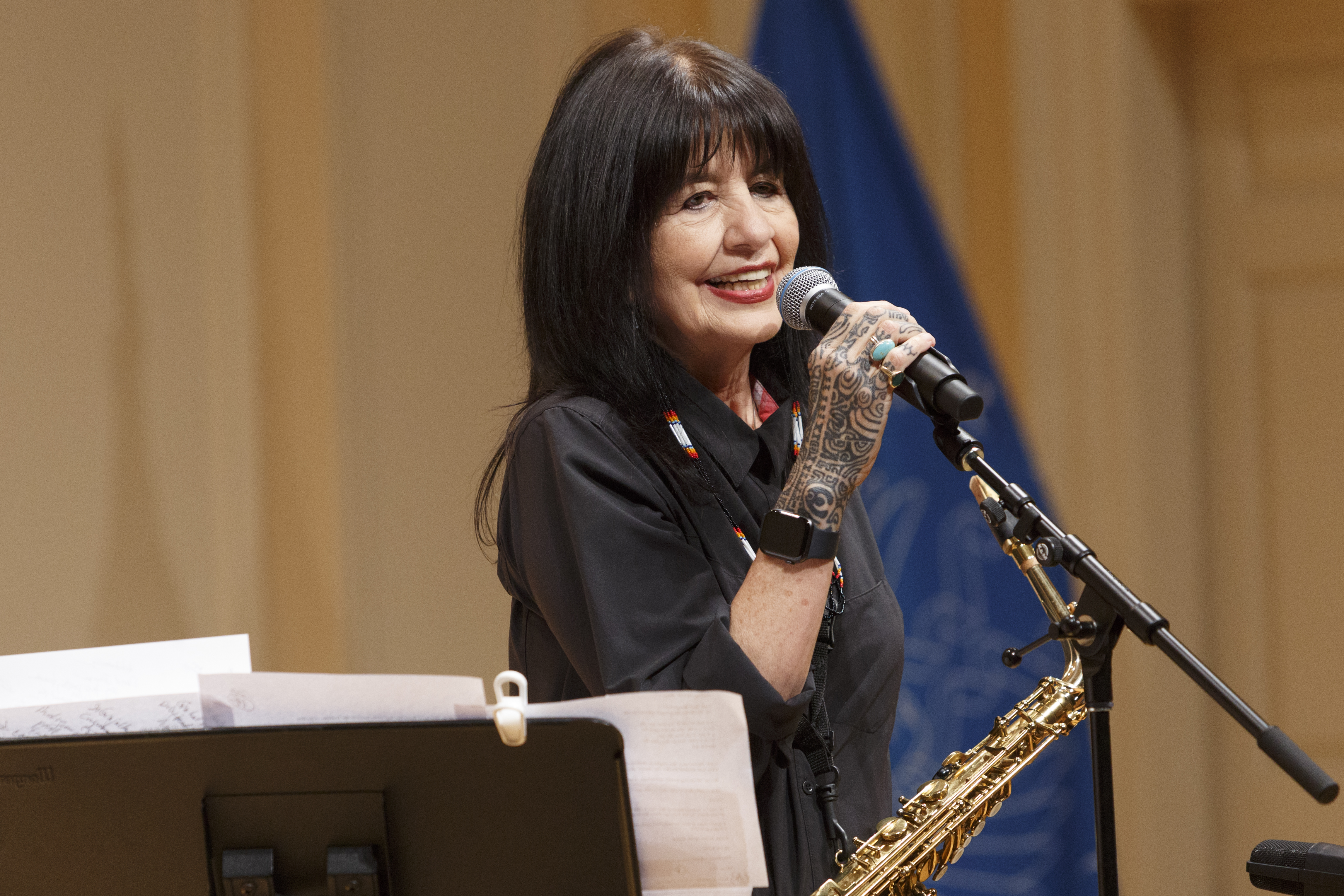 Photograph of writer and musician Joy Harjo holding a microphone.